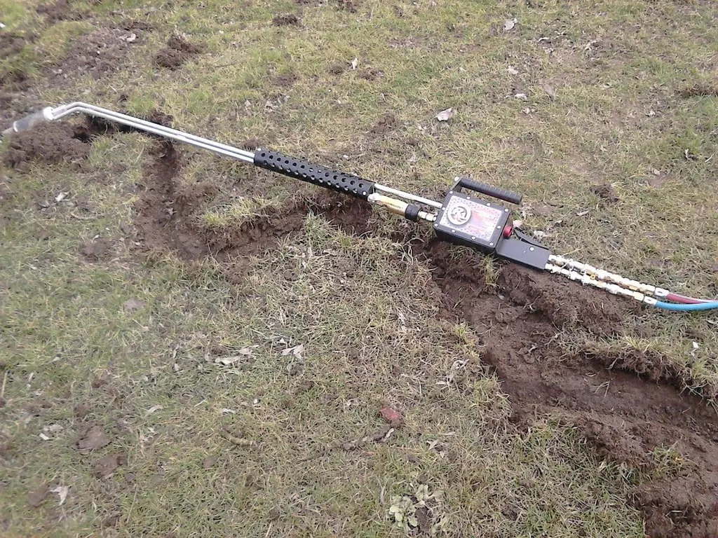 Sonda Rodenatoru zasunutá do hromádky hlíny v trávě